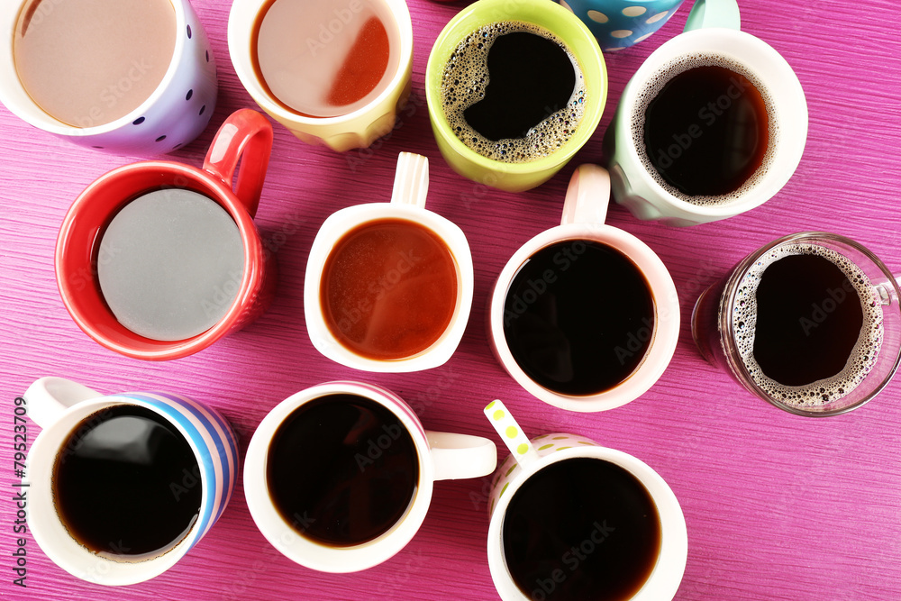 Many cups of coffee on color table, top view