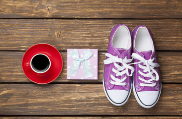 Gumshoes and gift box with coffee cup