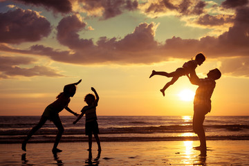 Wall Mural - Father and children playing on the beach