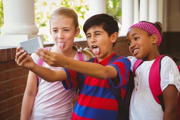 Wall Mural - School kids taking selfie in school corridor