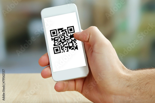 Fotografie, Obraz Hand holding smartphone with QR code on the screen