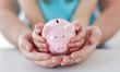 © Syda Productions - close up of family hands with piggy bank