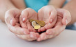 © Syda Productions - close up of family hands holding euro money coins