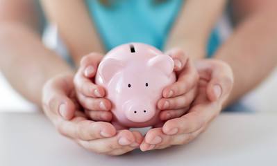 Wall Mural - close up of family hands with piggy bank