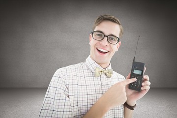 Poster - Composite image of geeky hipster holding a retro cellphone
