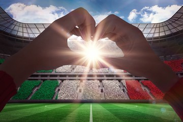 Poster - Composite image of woman making heart shape with hands