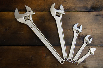 Spanner or adjustable wrench on wooden back ground