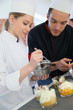 © goodluz - Chef with student in pastry making dessert