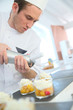 © goodluz - Pastry cook spreading whipped cream on dessert