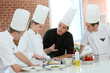© goodluz - Chef training students in restaurant kitchen
