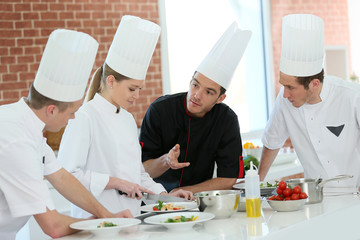 Chef training students in restaurant kitchen