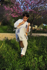 Wall Mural - Young girl in kimono w yellow belt exercising karate.