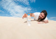 Thirsty man in the desert grabs water bottle