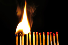 Line Of Lighted Matches On Black Background