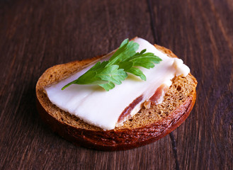 Wall Mural - Sandwich with lard and parsley on wooden background