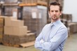 © WavebreakmediaMicro - Serious manager with arms crossed in warehouse