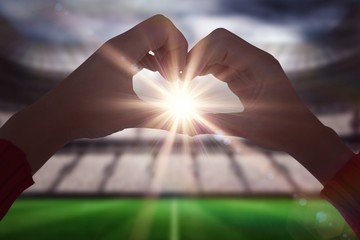 Poster - Composite image of woman making heart shape with hands