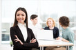 © Friends Stock - Businesswoman looking at camera with her business team on