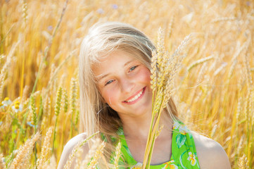 Wall Mural - Happy girl holding wheat ears