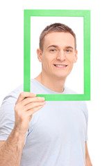 Canvas Print - Young man posing behind a green picture frame