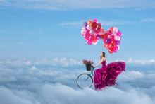 Woman In Beautiful Dress Flying On Her Bike
