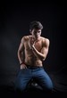 © theartofphoto - Handsome muscular shirtless young man kneeling down on the floor