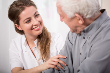 Smiling nurse assisting senior man