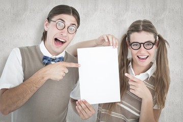 Poster - Composite image of geeky hipsters pointing at poster