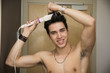 © theartofphoto - Smiling Bare Handsome Man Ironing his Hair
