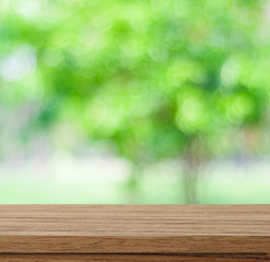 Empty wood table over blurred trees with bokeh background