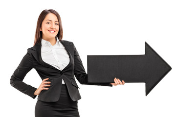 Wall Mural - Smiling woman holding a big arrow pointing right