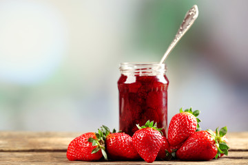 Wall Mural - Jar of strawberry jam with berries on table on bright