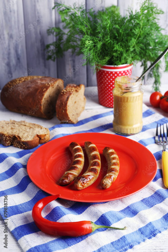 Grilled sausages on plate on table close up