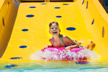 Wall Mural - Child on water slide at aquapark.