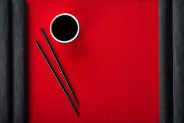 Wall Mural - Chopsticks and bowl with soy sauce on cotton mat top view