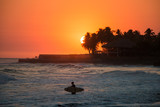 Fototapeta Big Ben - Surfer in the water during a sunset at Playa el Tunco, El Salvad