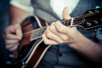 close up hands hipster man playing mandolin