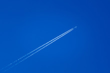 Airplane In The Sky With Plane Trails