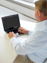 Wall Mural - close up of senior man with laptop typing