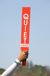 The quiet please sign was held up by volunteer in golf tournamen