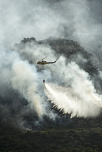 Fire Fighting Helicopter Dropping Water On A Fire