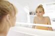 © Westend61 - Woman looking at her mirror image in the bathroom