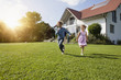 © Westend61 - Brother and sister running in garden