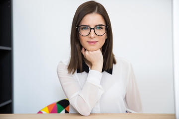 Canvas Print - Happy young cute businesswoman sitting at her workplace