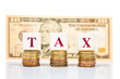 © ThamKC - TAX concept with stack of coin and US Dollar as backdrop