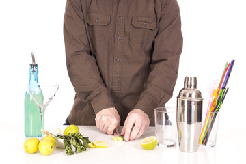 Wall Mural - Bartender preparing mojito cocktail drink, with limes, ice and b