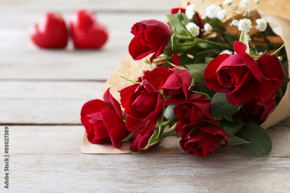 Red roses wrapped in paper with hearts