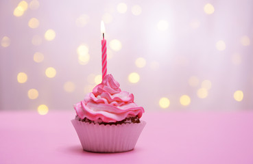 Wall Mural - Delicious birthday cupcake on table on light background