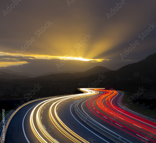 Fotomural Sunset with car lights on highway