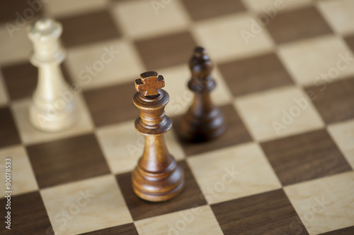 Fotografia, Obraz Chess pieces and game board background; focus on king